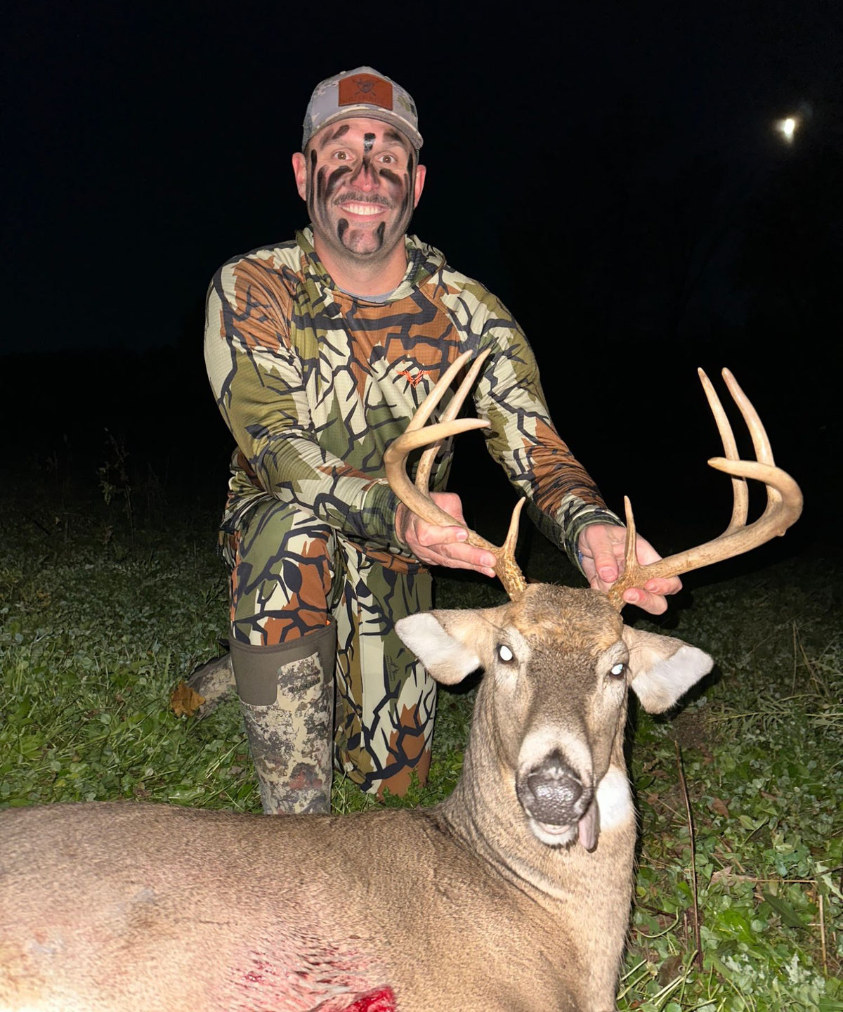 Plot Twist owner Matt kneeling with a harvested whitetail buck